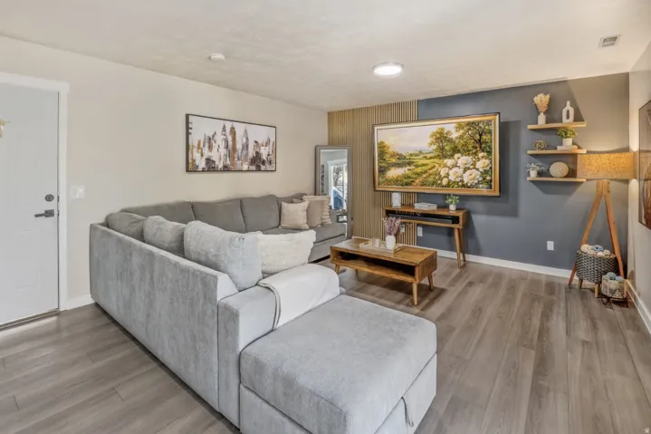 Living room featuring wood finished floors and an accent wall