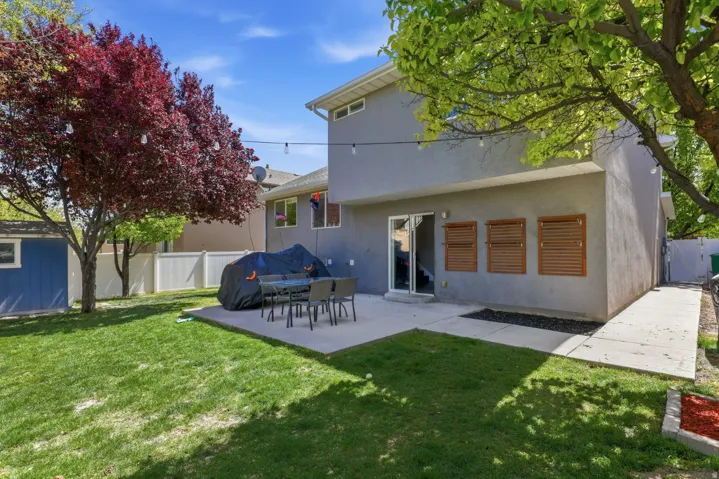 Rear view of property featuring a fenced backyard, a patio area, and stucco siding