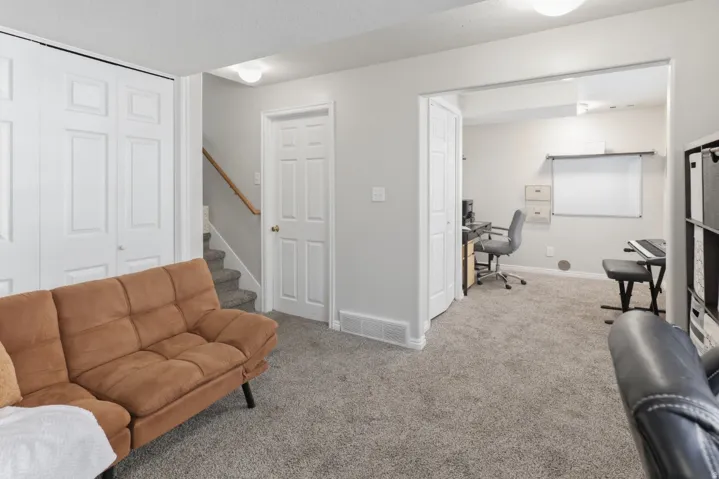Carpeted living room with an office area and baseboards