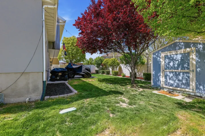 Fenced backyard featuring a storage shed