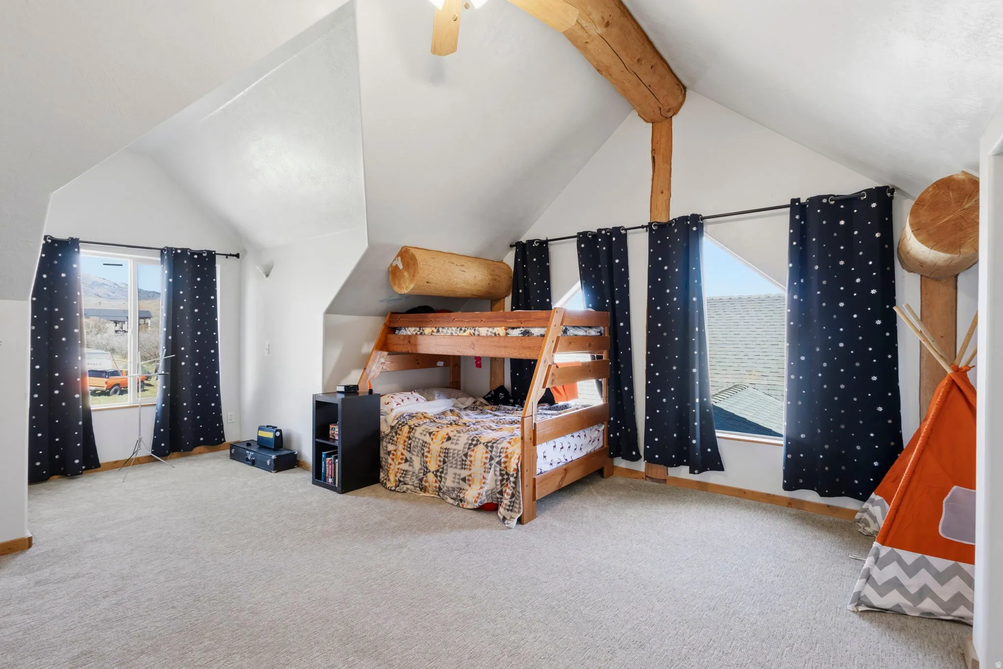 Bedroom with light carpet and beam ceiling