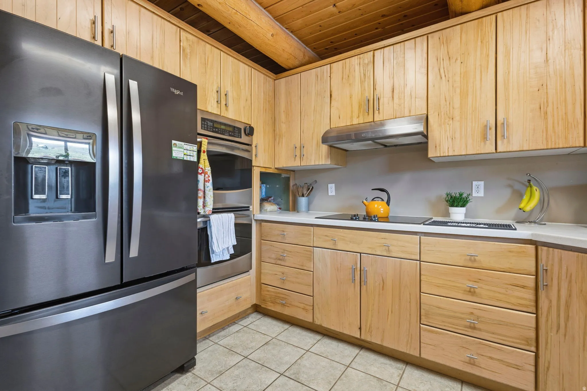 Kitchen featuring stainless steel appliances, light wood finish cabinets, light countertops, and wooden ceiling
