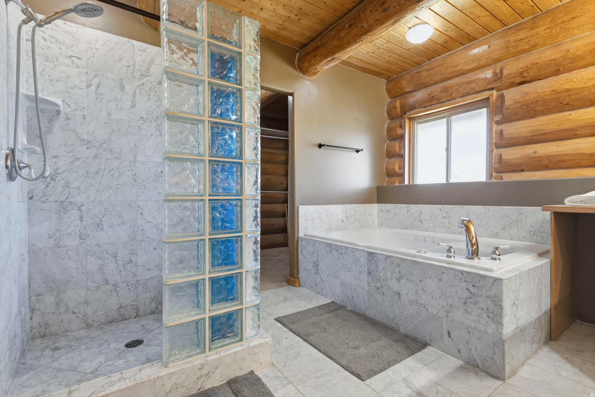 Full bath with rustic walls, walk in shower, a bath, a wooden ceiling with exposed beams, and vanity