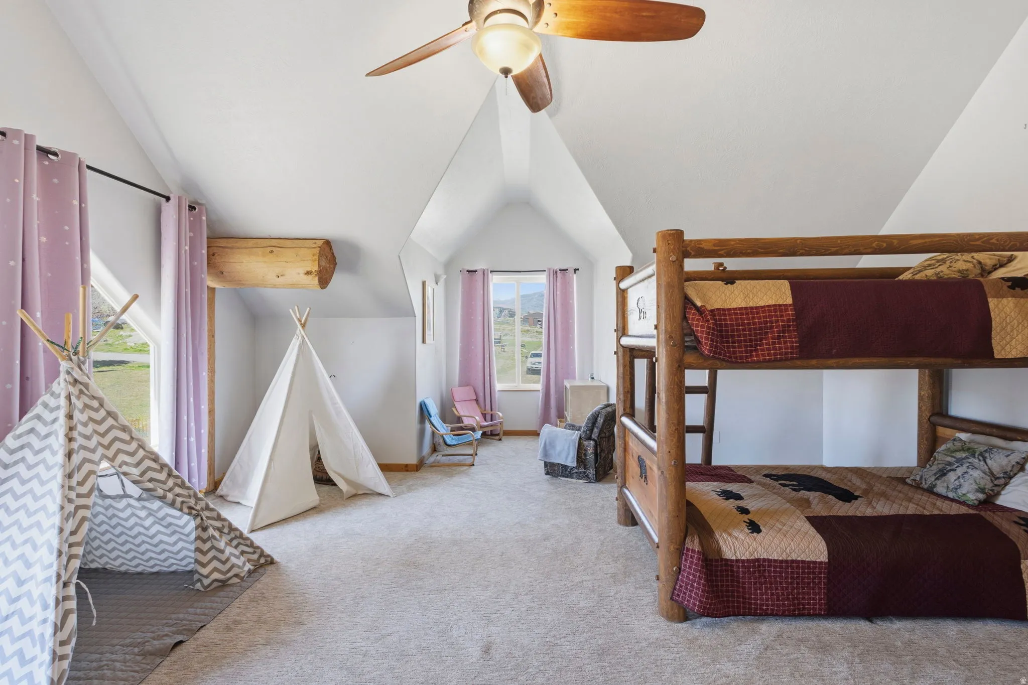 Carpeted bedroom featuring a ceiling fan and lofted ceiling