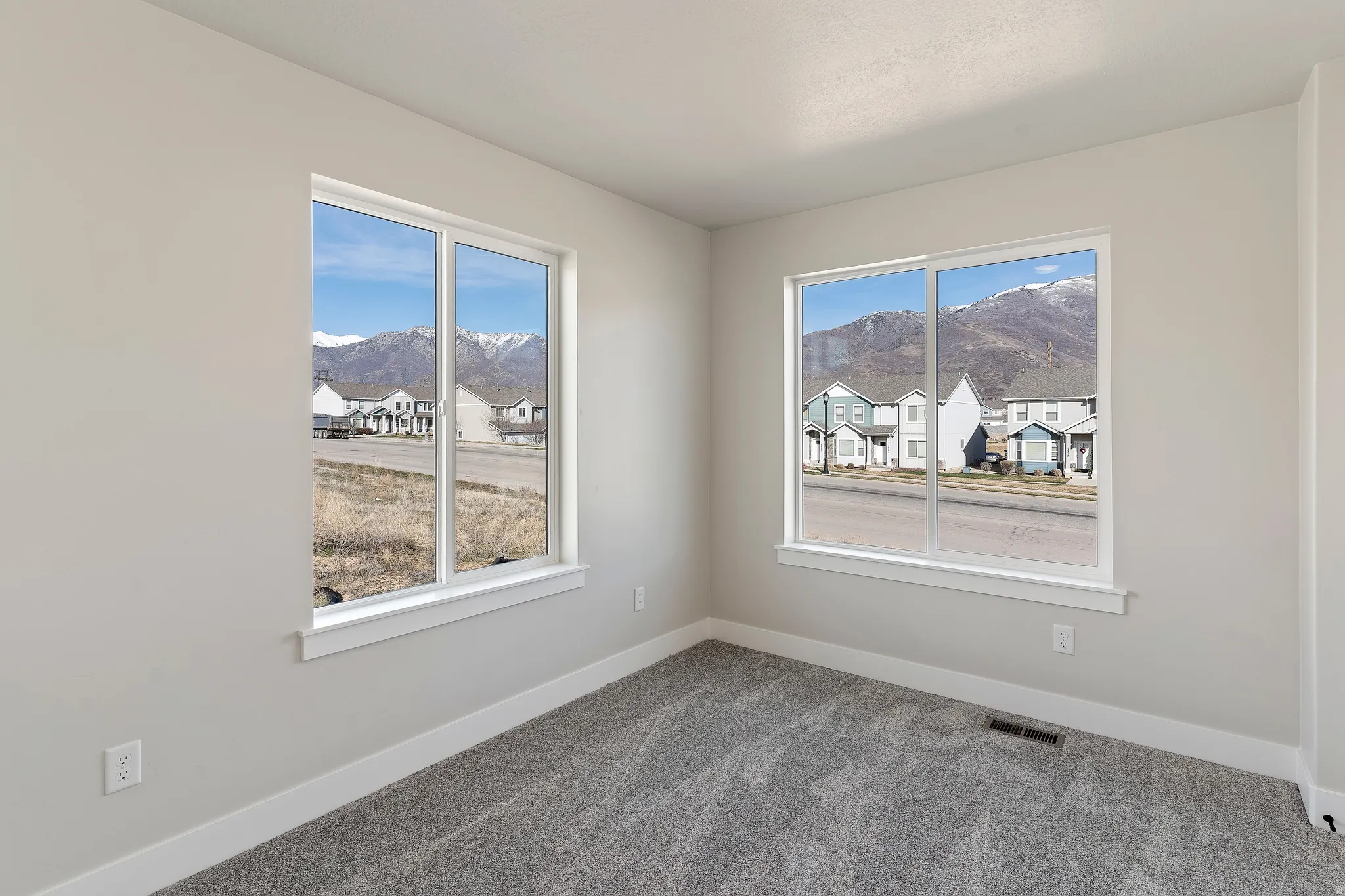 Neutral tone interior featuring light gray walls, white trim, and gray patterned carpet