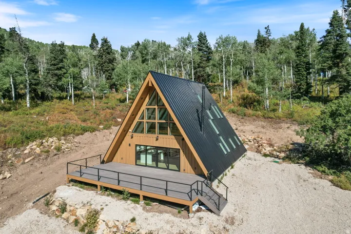 A-frame architecture featuring a dark metal roof and light wood siding