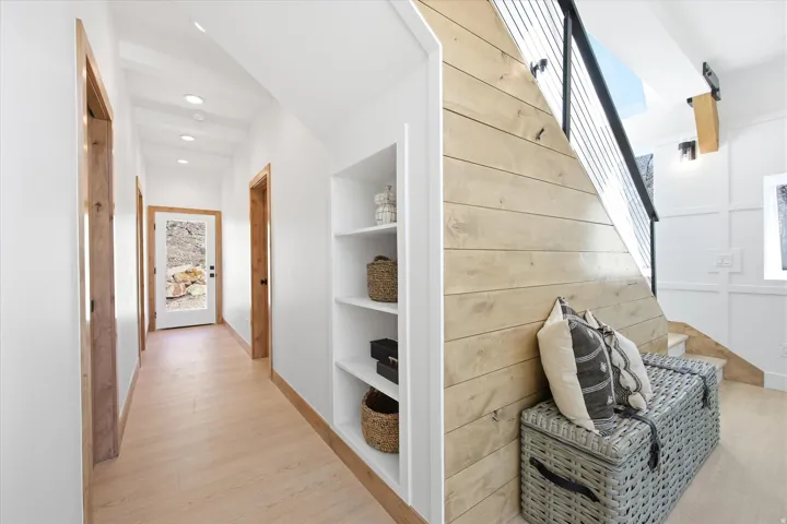 Hallway featuring built-in shelving, recessed ceiling lighting, and light wood-finish flooring