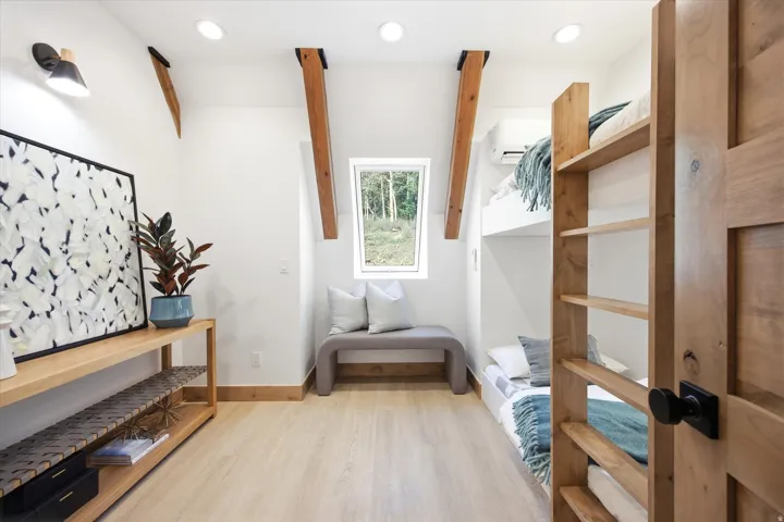 Room featuring built-in bunk beds, light wood-finish flooring, and white walls