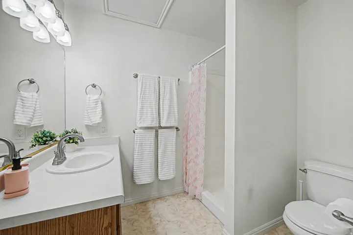 2nd Bathroom featuring a single vanity with an integrated sink, brushed nickel faucet, and a large wall mirror
