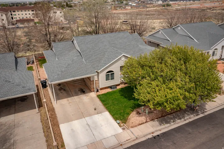 Single-story residence featuring a covered carport, concrete driveway, and a light-colored exterior facade