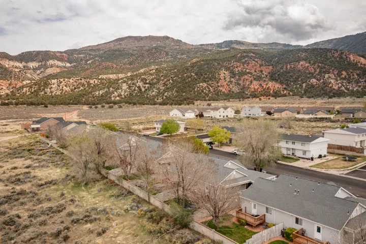 Residential street with various home styles set against a prominent mountainous backdrop
