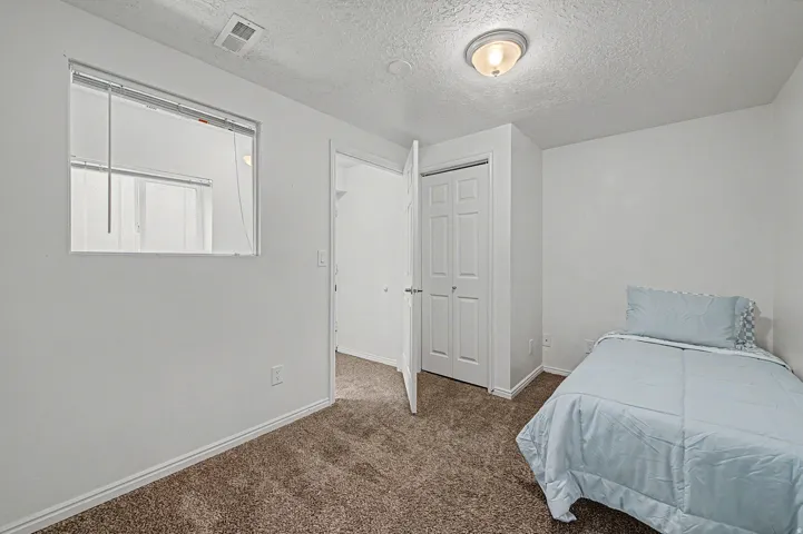 5th bedroom Carpeted interior room a bi-fold closet door
