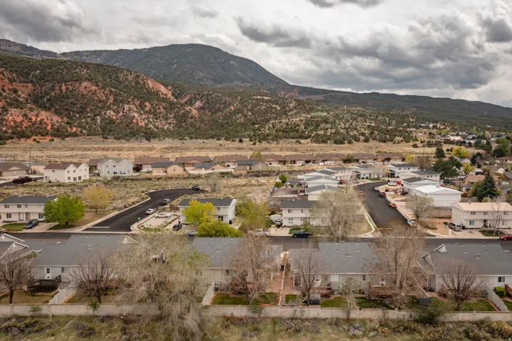 Residential neighborhood featuring mountain backdrops, paved streets, and varied property styles