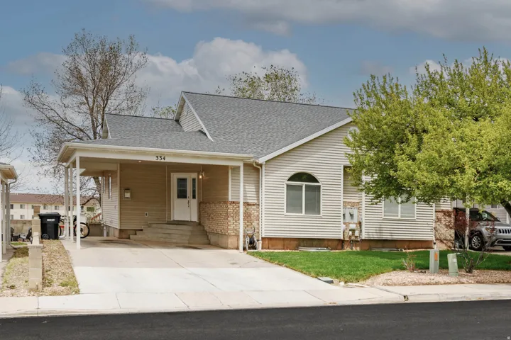 Property exterior featuring horizontal siding and brick accents, a covered carport, and an arched window detail