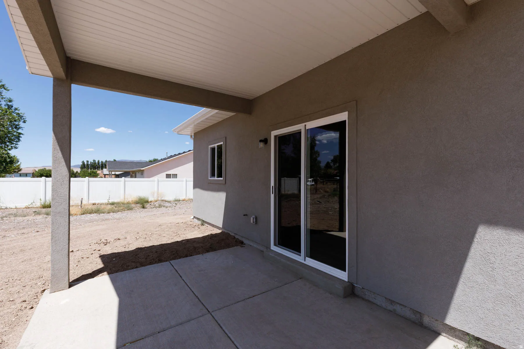 Covered patio featuring a concrete slab and stucco finish