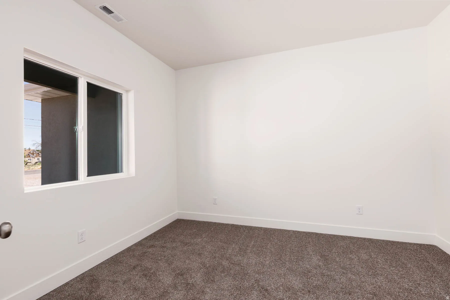 Neutral-toned carpeting paired with white baseboards and walls