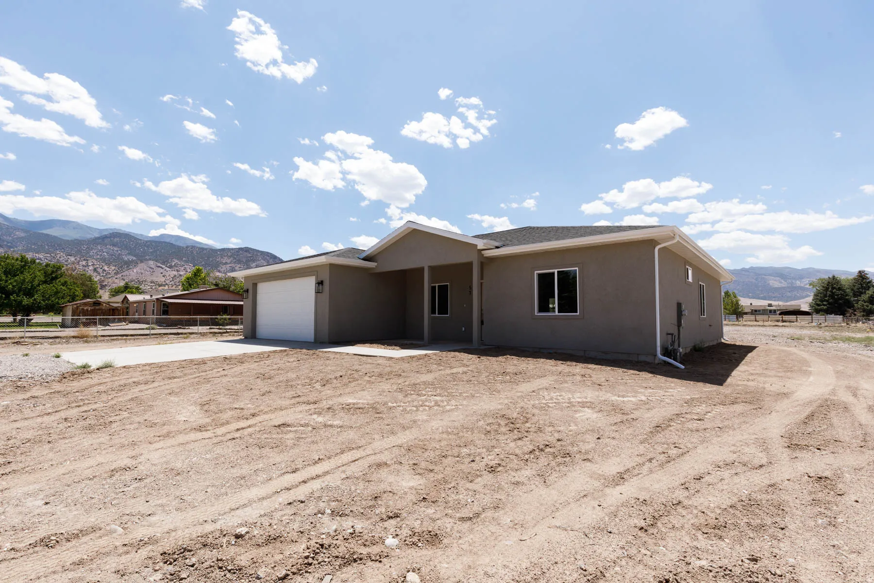 Single-story residence featuring stucco exterior, attached garage, covered entryway, dark-frame windows, and a newly installed asphalt shingle roof