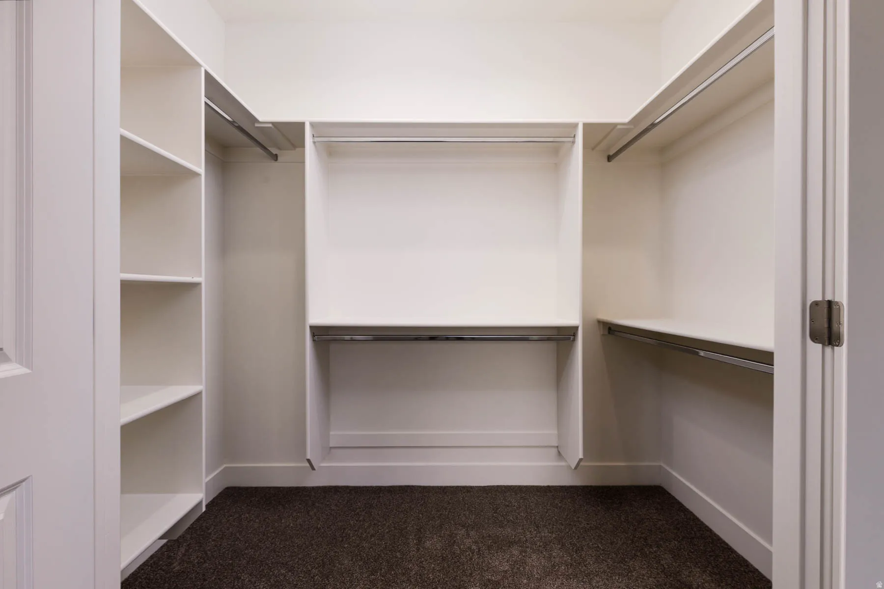 Walk-in closet featuring built-in shelving, multiple hanging rods, and ample storage space