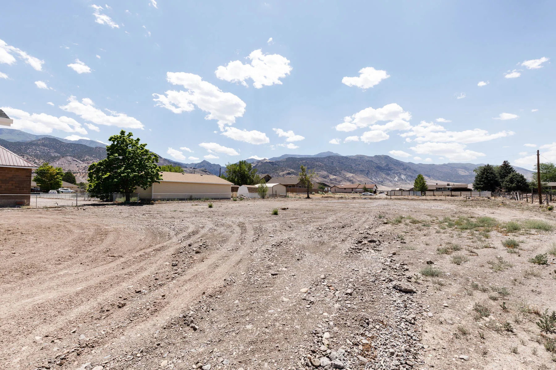 Expansive gravel lot with surrounding mountain landscape