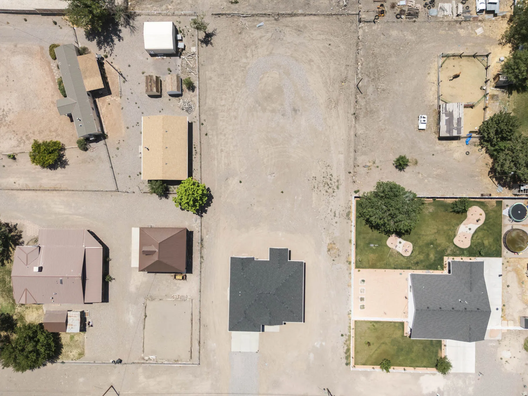 Aerial view showcasing multiple properties with unpaved surroundings