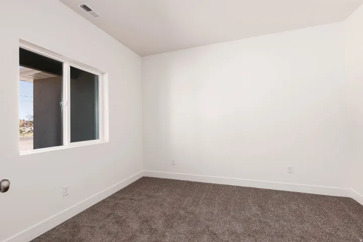 Neutral-toned carpeting paired with white baseboards and walls