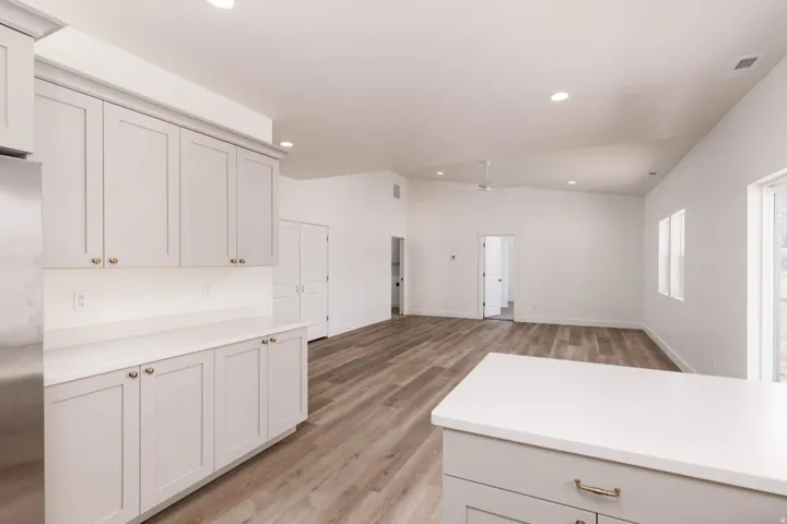 Kitchen featuring light gray cabinetry with gold-toned hardware, white countertops, and stainless steel appliances