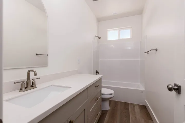 Neutral-toned vanity with an integrated sink and brushed nickel faucet, set against white walls