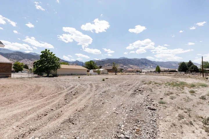 Expansive gravel lot with surrounding mountain landscape