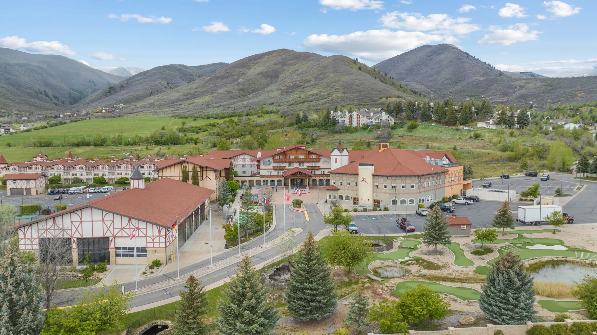 Expansive property featuring multiple buildings with distinctive architectural styles, including visible timber framing and red tile roofing