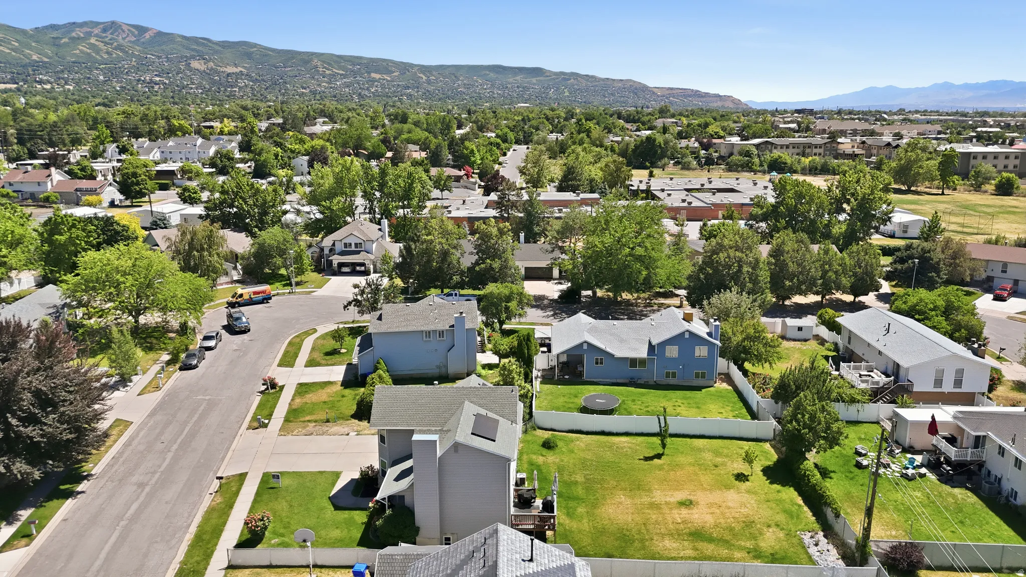 Residential neighborhood featuring mature trees and mountain backdrops