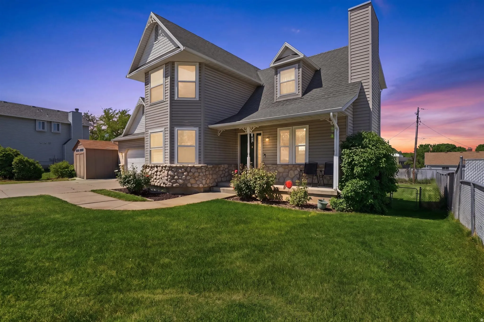 Two-story residence featuring grey horizontal siding and a prominent front-facing gable