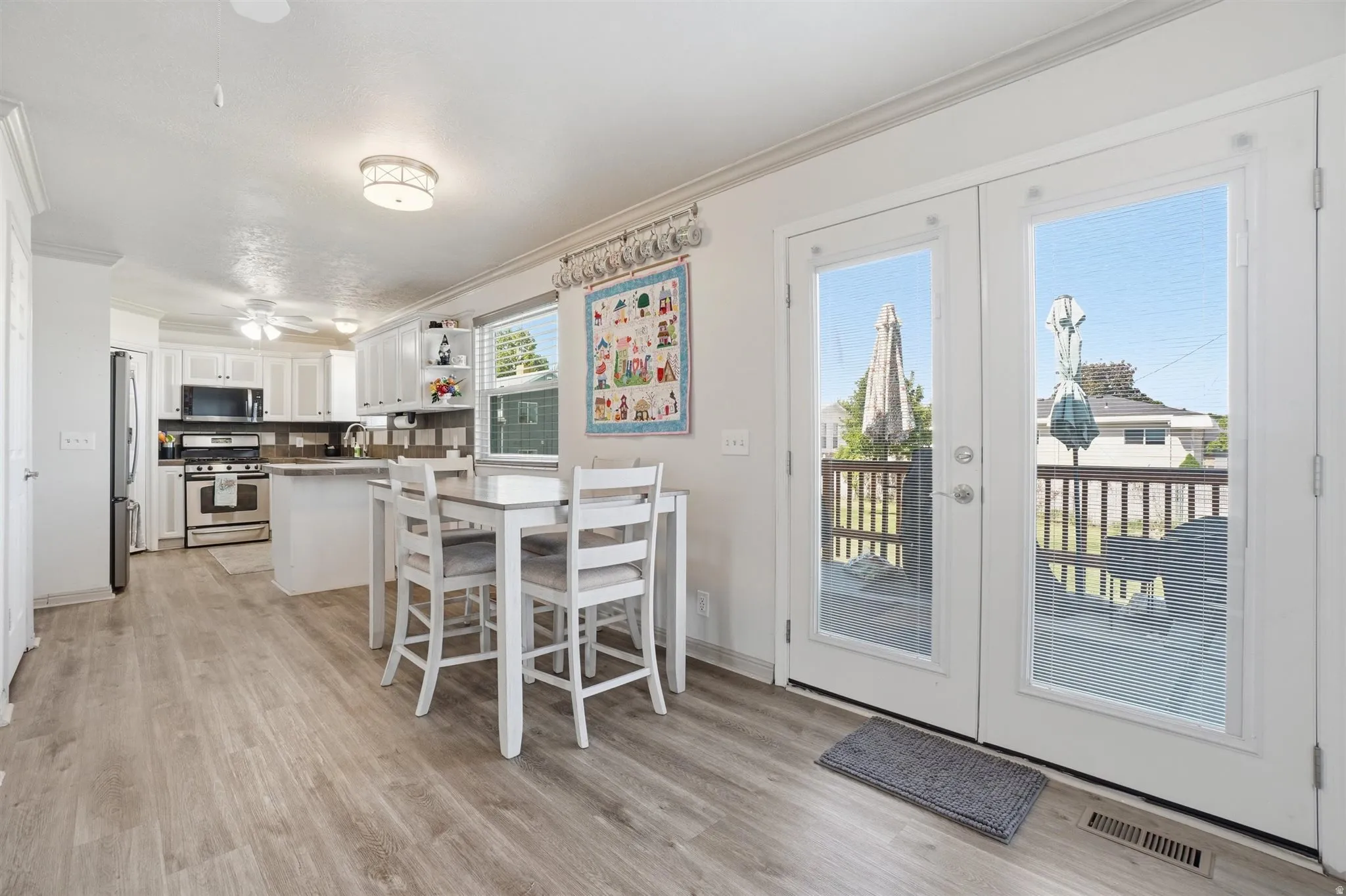 Bright kitchen and dining area featuring French doors leading to an outdoor deck