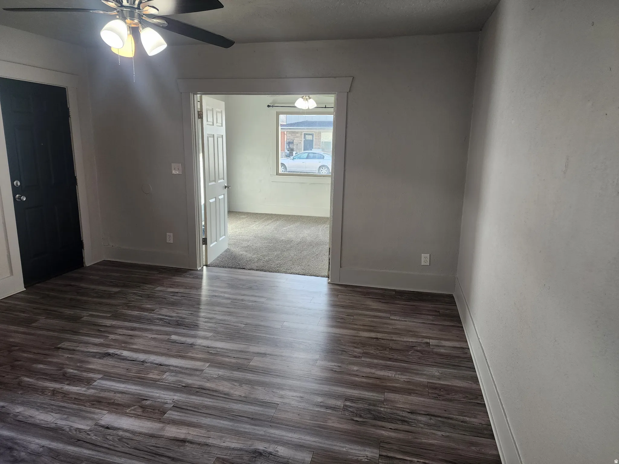 Unfurnished room with ceiling fan and dark wood-style flooring
