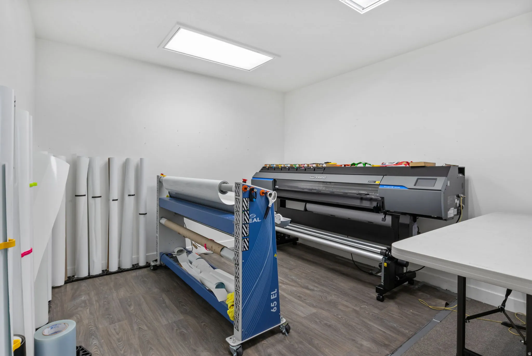 White walls with recessed ceiling lighting and wood-finish flooring