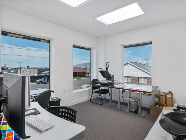 Bright interior space featuring three large windows, white walls, and recessed ceiling lighting