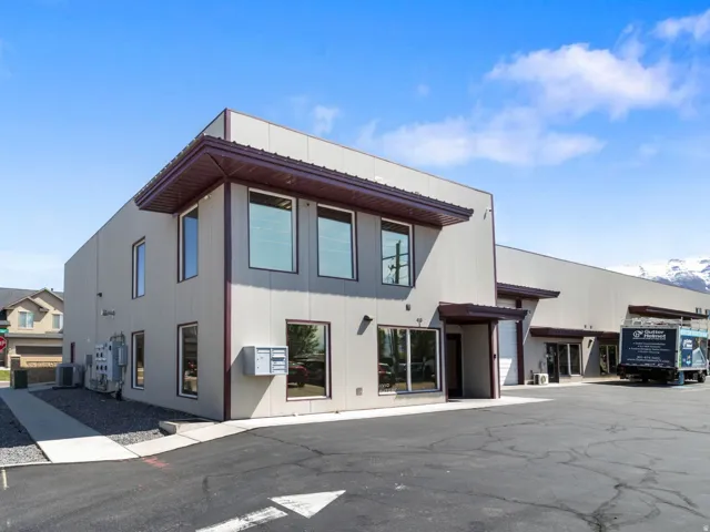 Contemporary commercial building with a light-toned stucco facade and dark trim accents