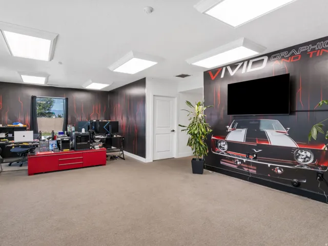 Spacious room featuring carpet flooring, recessed lighting, a large window, and a wall-mounted display
