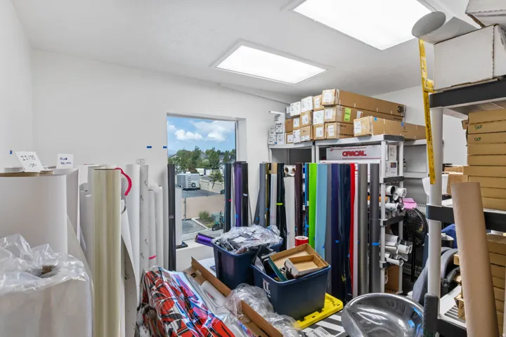 White-painted interior space featuring a large window, two recessed lighting fixtures, and high ceilings