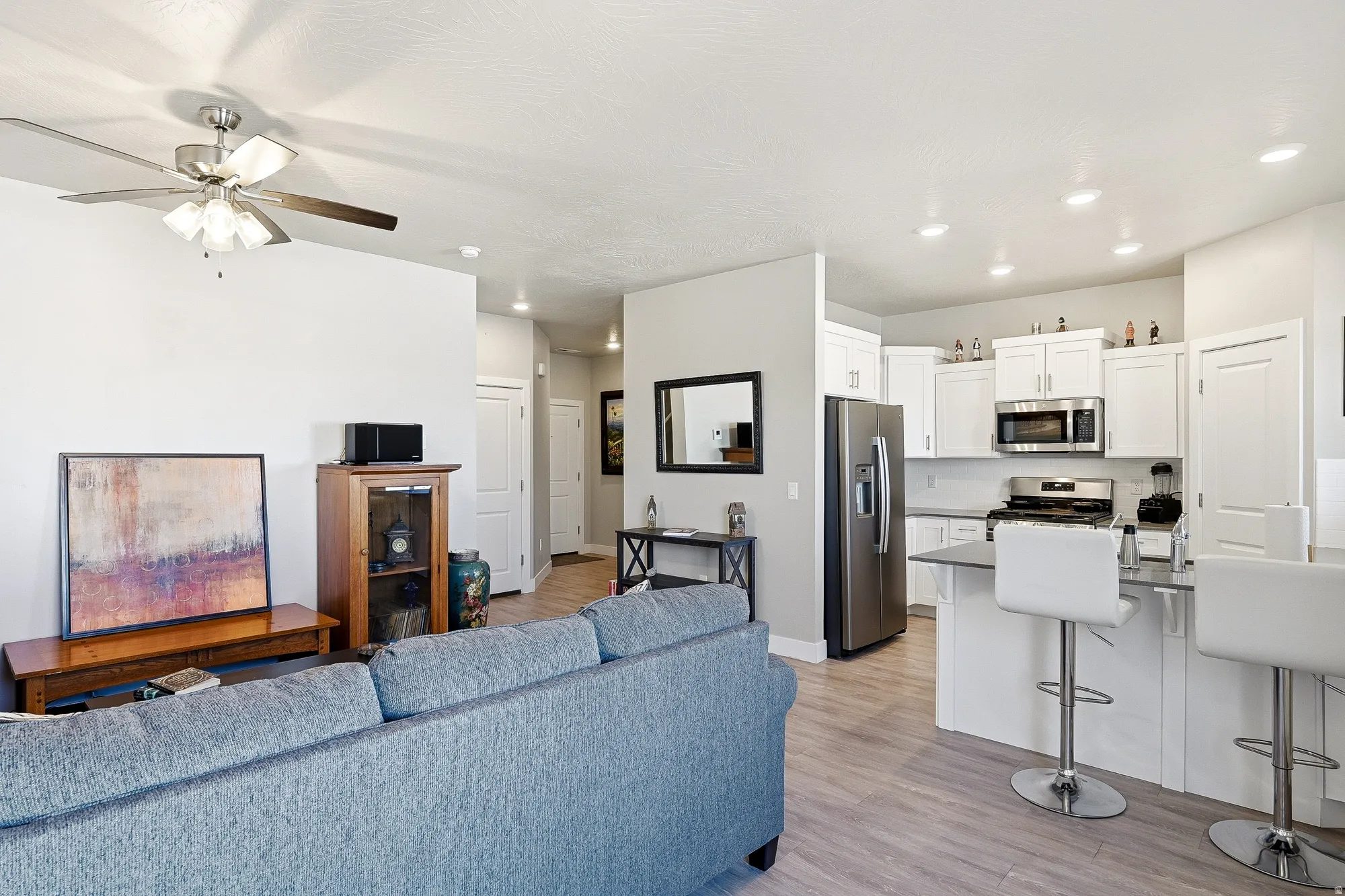 Open-concept living area featuring wood-finish flooring and recessed lighting