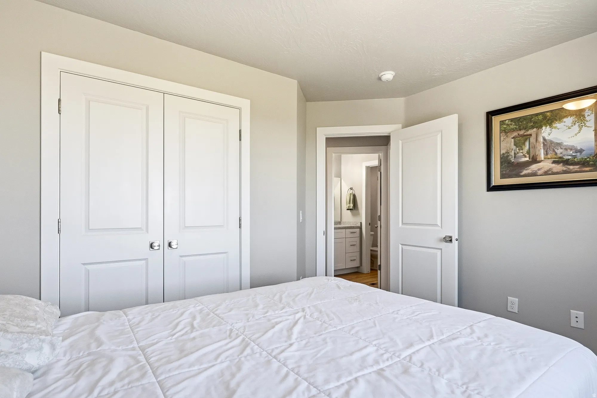 Interior room featuring light gray wall paint and white trim, with a closet showcasing double panel doors