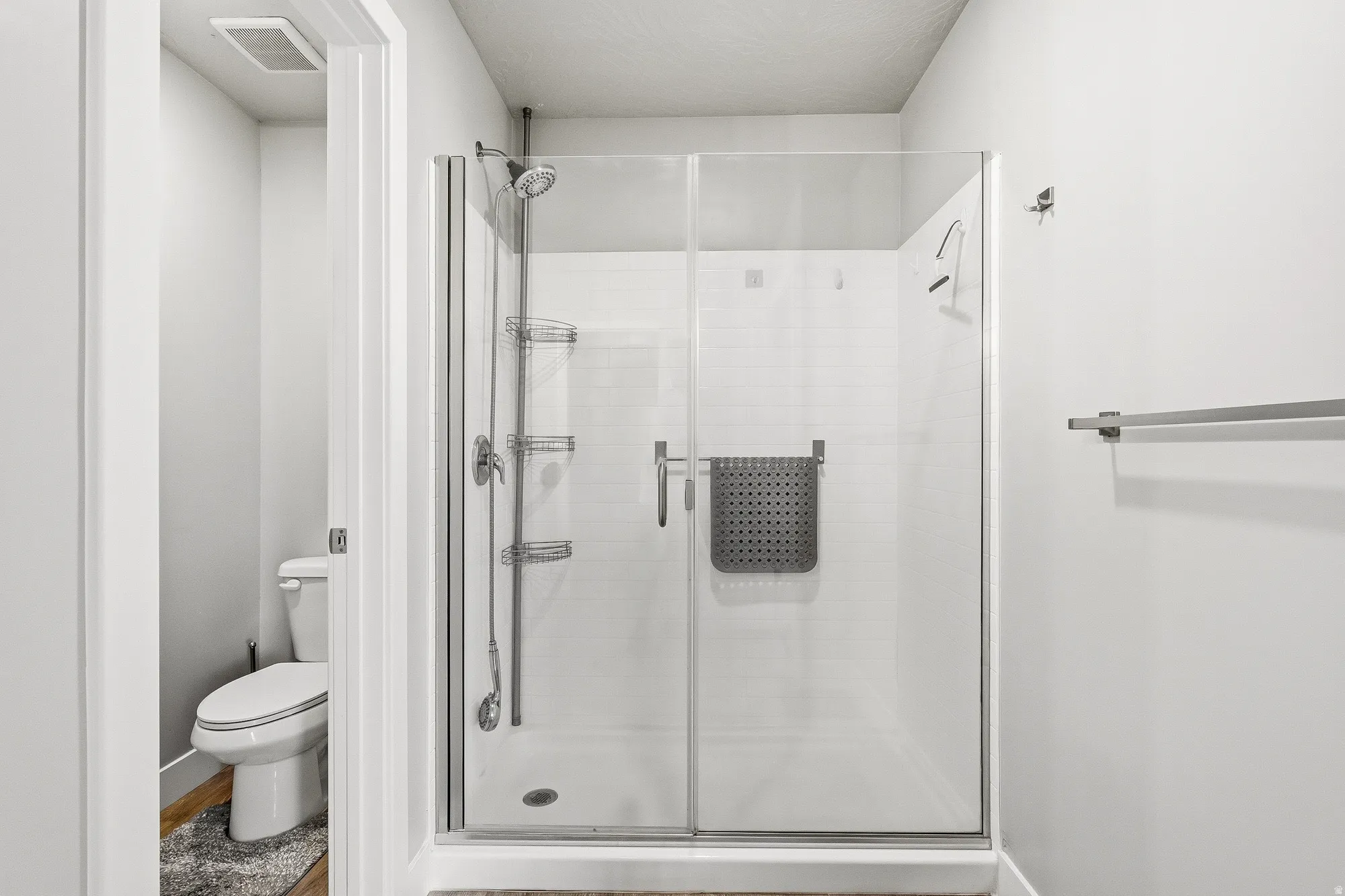 Spacious walk-in shower with clear glass enclosure and white subway tile surround
