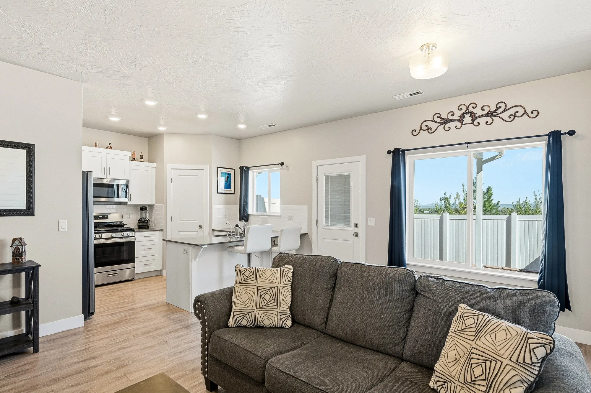 Open-concept living area featuring wood-finish flooring and recessed lighting