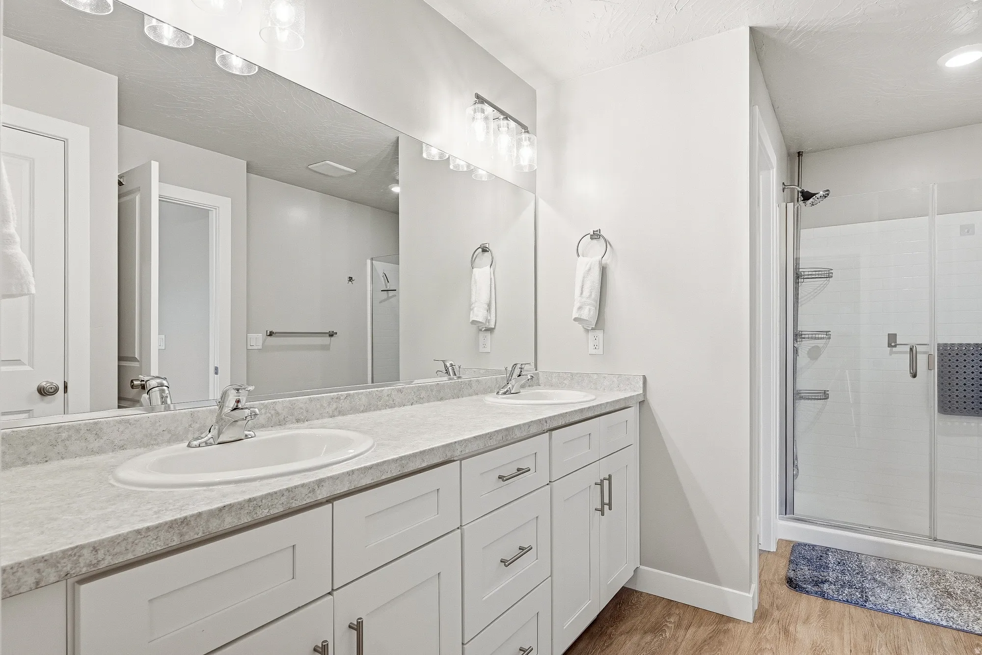 Double vanity with white cabinetry and integrated sinks, complemented by a light-toned countertop
