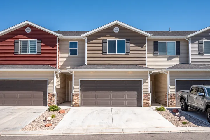 Townhome exterior featuring tan and brown siding with stone accents