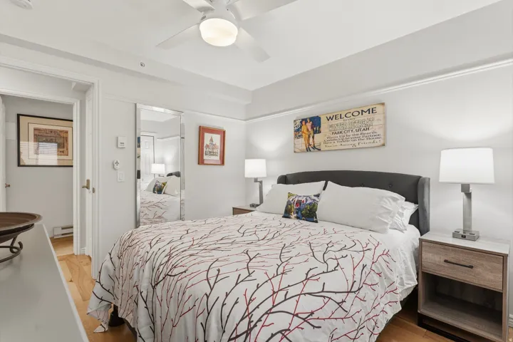 Bedroom with light wood-type flooring, ceiling fan, and a baseboard radiator