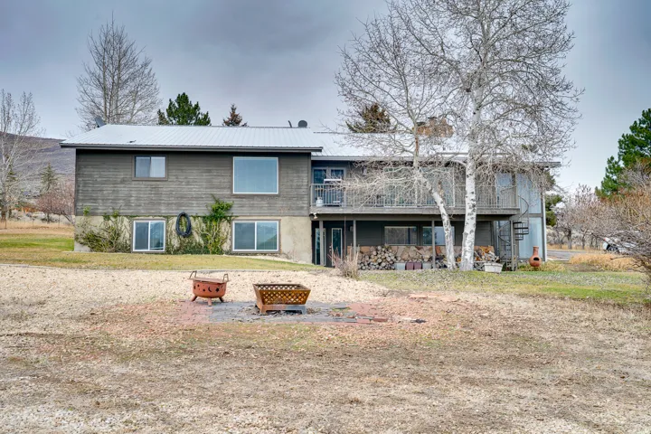 Multi-level residence featuring a metal roof, wood siding, and multiple balconies