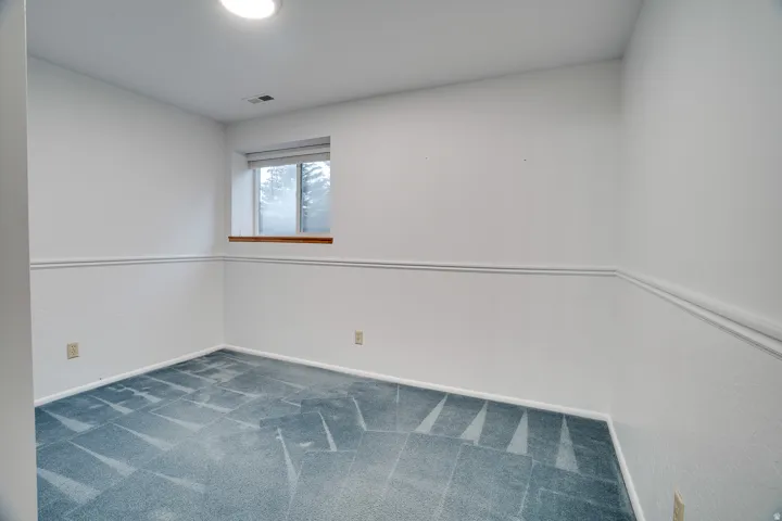 Bright room featuring a single window, recessed lighting, and patterned carpeting