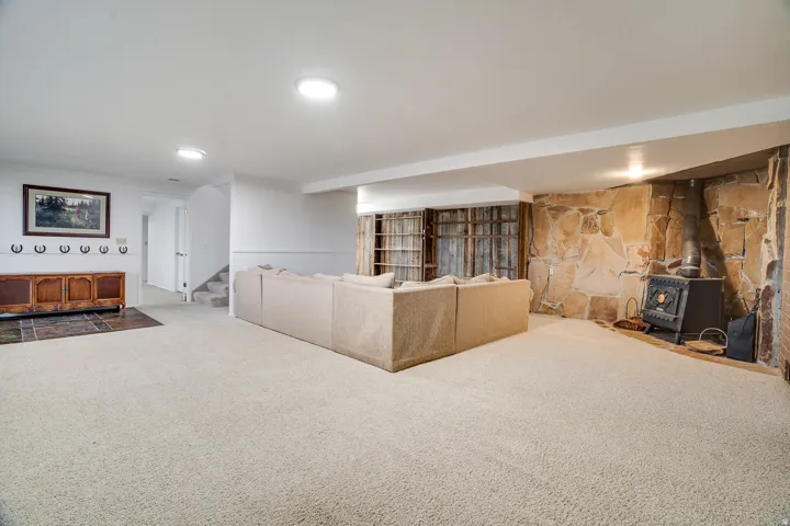 Open room featuring carpet flooring, recessed lighting, and a stone accent wall