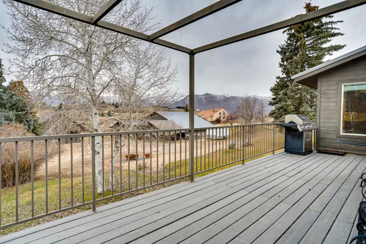 Spacious outdoor deck featuring composite decking, metal railings, and an open pergola structure