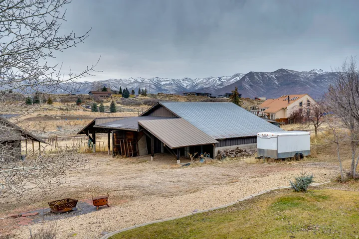 Expansive property featuring multiple outbuildings, metal roofing, and a gravel driveway